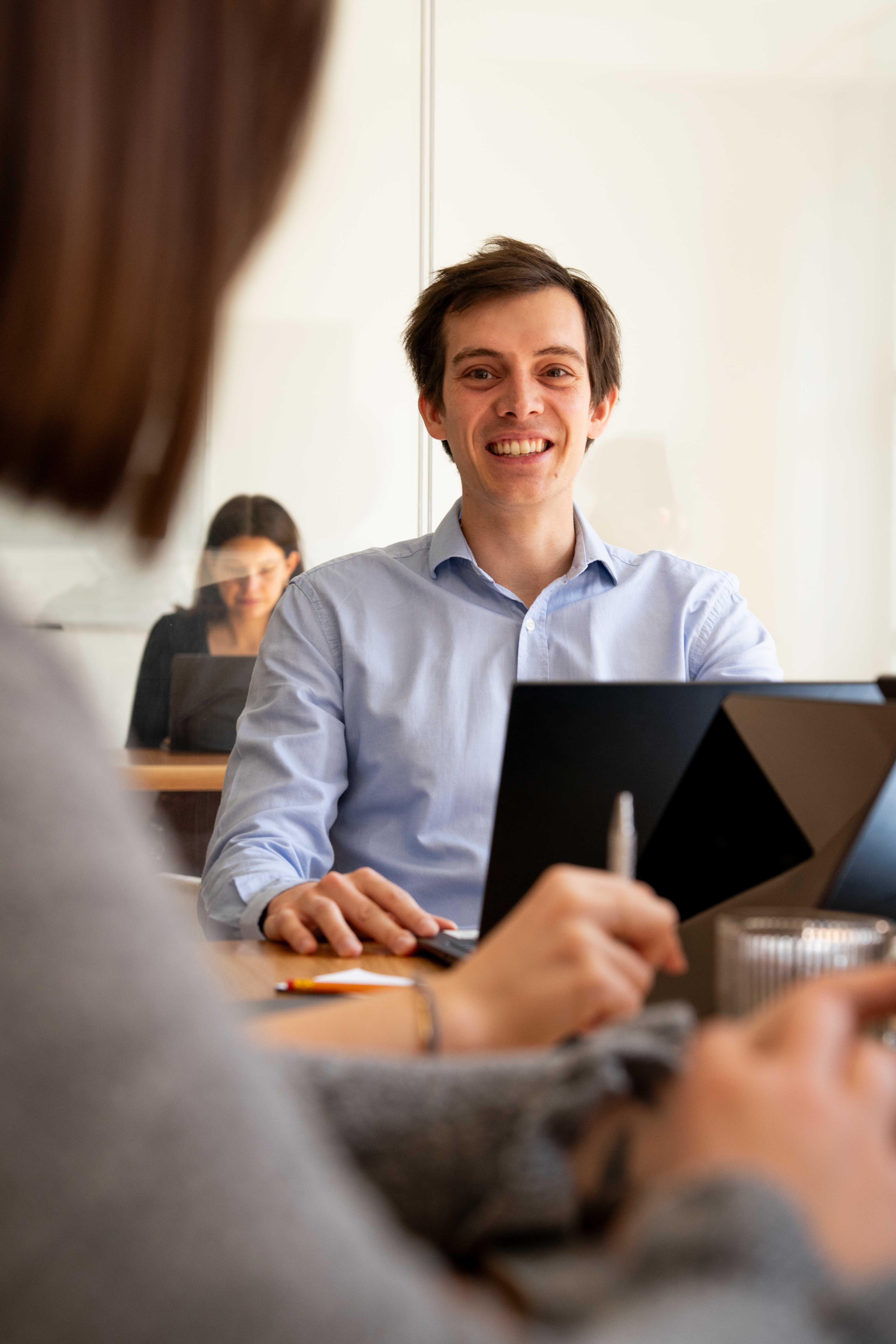 Ein Galadrim Team im Workshop an einem Besprechungstisch, Laptops geöffnet
